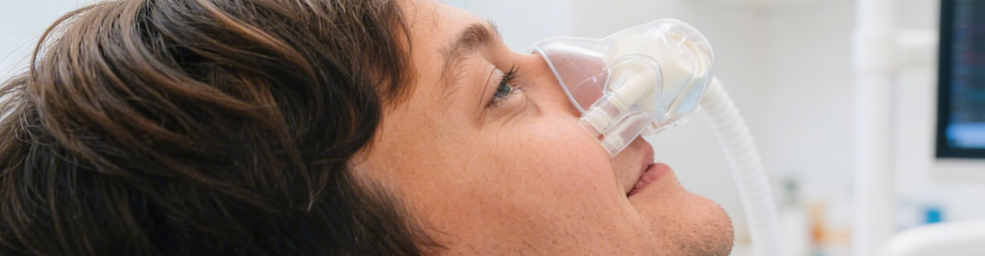 Man in dental chair with sedation apparatus over his nose.